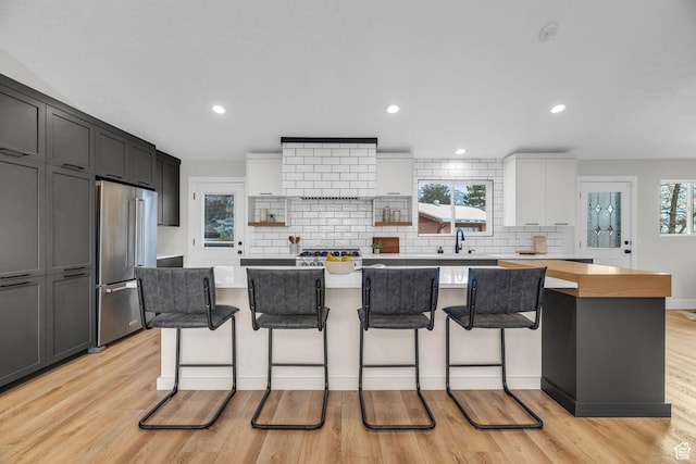 kitchen with a kitchen island, light countertops, high end fridge, and decorative backsplash