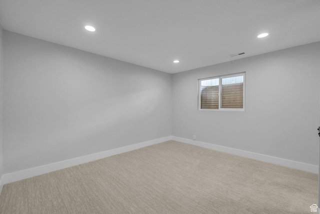 empty room featuring visible vents, recessed lighting, and carpet flooring
