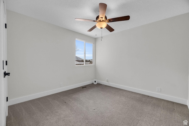 carpeted empty room featuring baseboards and ceiling fan