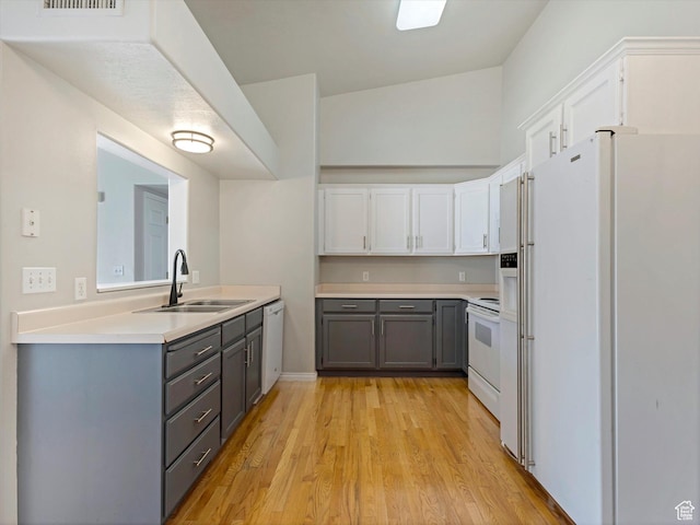 kitchen featuring gray cabinets, sink, white appliances, white cabinetry, and light wood-type flooring