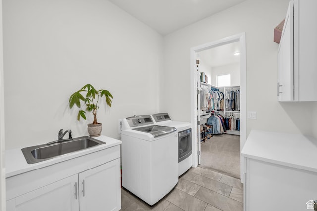 laundry room featuring light carpet, sink, washing machine and clothes dryer, and cabinets