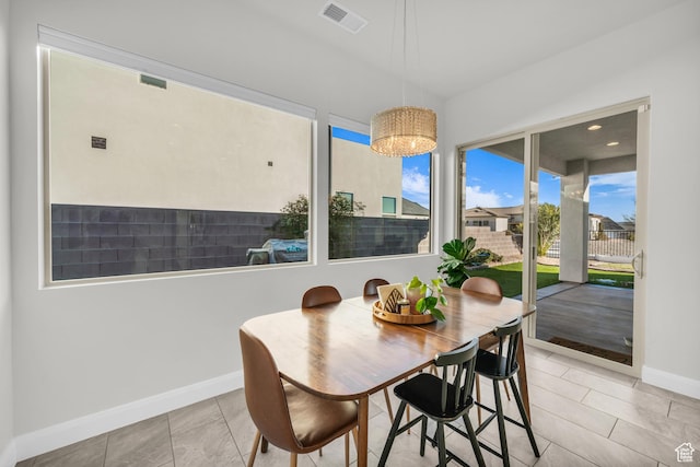 tiled dining space featuring a notable chandelier