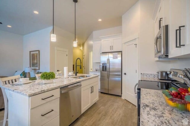 kitchen featuring white cabinetry, a center island with sink, a breakfast bar area, stainless steel appliances, and sink