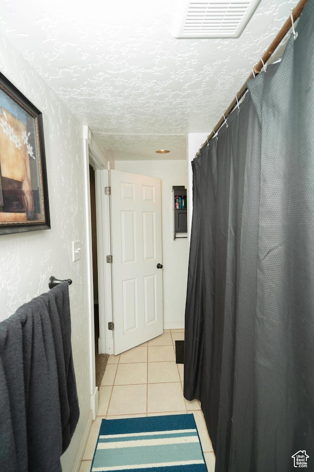 bathroom with tile patterned floors and a textured ceiling