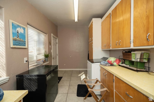 laundry area with cabinets and light tile patterned floors