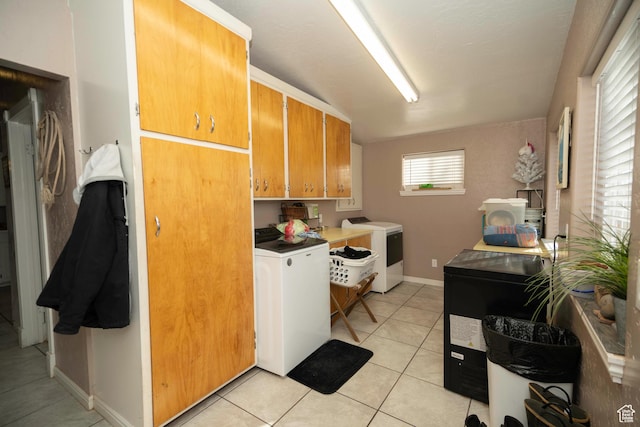 laundry area with cabinets, separate washer and dryer, and light tile patterned floors