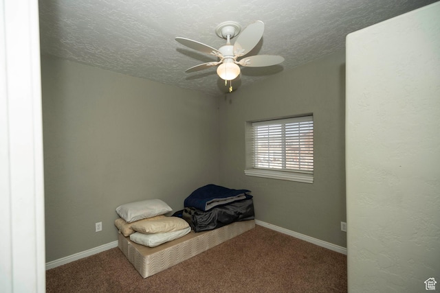 unfurnished bedroom featuring carpet, a textured ceiling, and ceiling fan