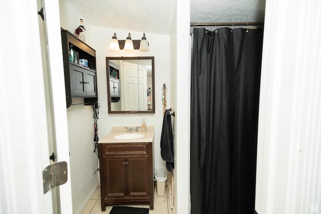 bathroom featuring tile patterned flooring, vanity, a textured ceiling, and a shower with curtain