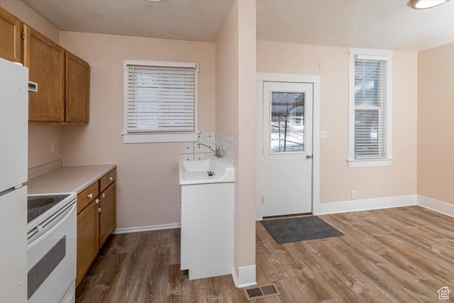 119 N 200 E, Smithfield, UT 84335 - kitchen featuring white appliances, wood finished floors, brown cabinetry, and a sink