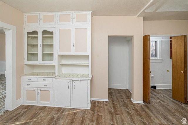 119 N 200 E, Smithfield, UT 84335 - kitchen featuring dark wood finished floors, light countertops, glass insert cabinets, white cabinetry, and baseboards