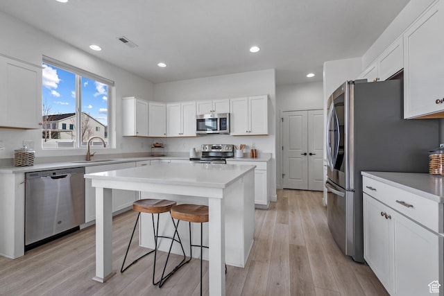 328 W 720th St S, American Fork, UT 84003 - kitchen featuring appliances with stainless steel finishes, a breakfast bar, sink, white cabinets, and a center island