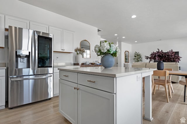 328 W 720th St S, American Fork, UT 84003 - kitchen with white cabinets, a kitchen island, stainless steel fridge, and light hardwood / wood-style flooring