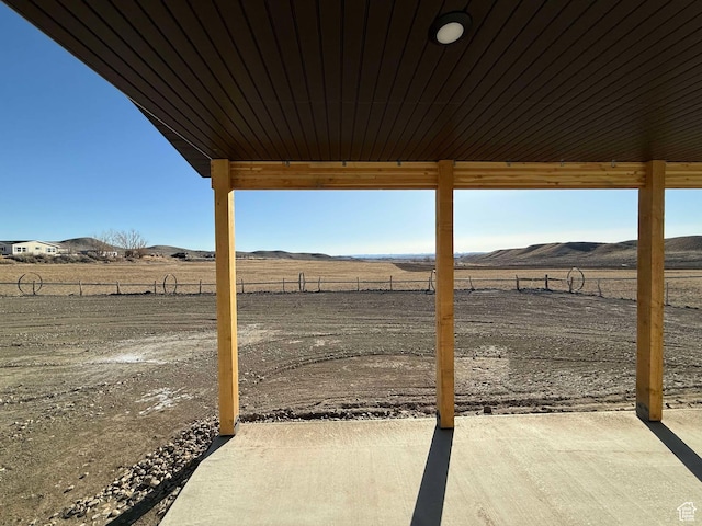 exterior space featuring a rural view, fence, and a mountain view