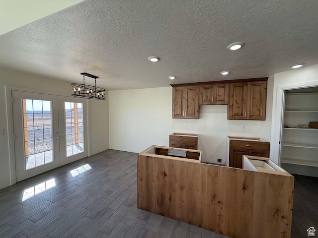kitchen with dark wood-style flooring, a chandelier, brown cabinets, recessed lighting, and french doors