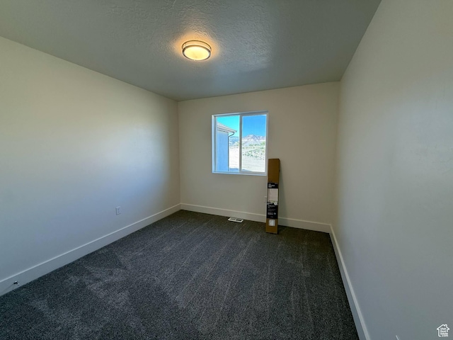 1030 N 200 E, Ferron, UT 84523 - spare room featuring baseboards, dark colored carpet, and a textured ceiling
