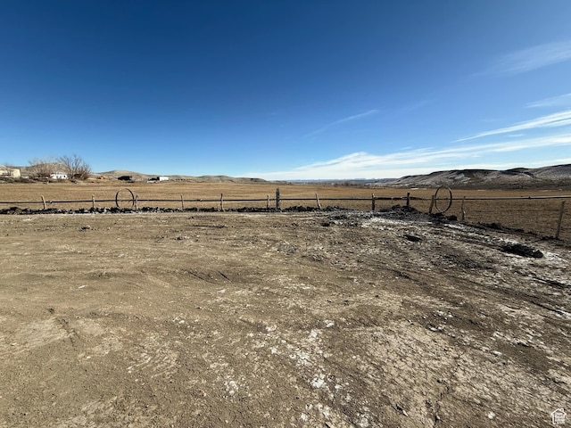 view of yard featuring a mountain view, fence, and a rural view