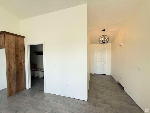 interior space featuring vaulted ceiling, wood finished floors, and an inviting chandelier