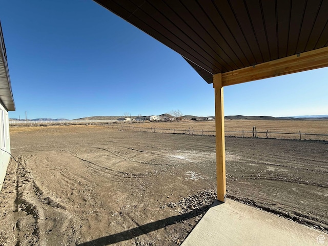 view of yard with a mountain view, fence, and a rural view