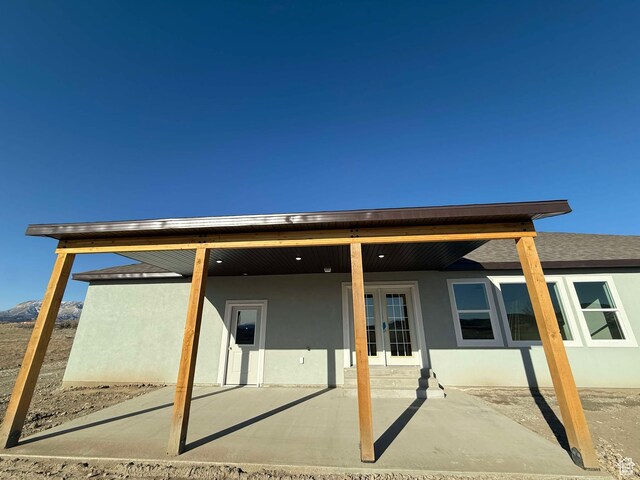 back of property featuring stucco siding and french doors