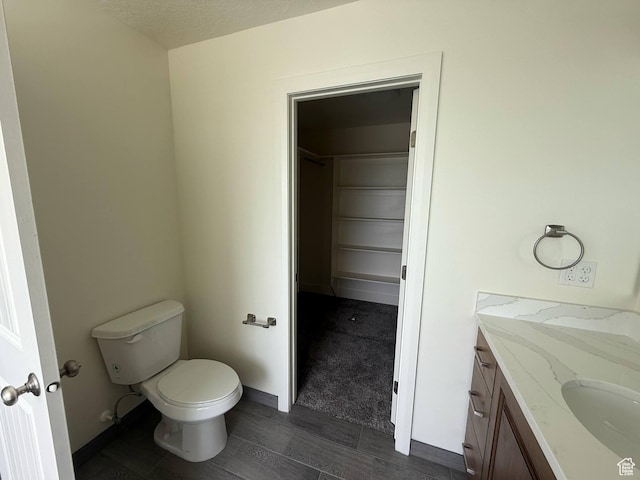 1030 N 200 E, Ferron, UT 84523 - bathroom featuring toilet, vanity, wood finished floors, and a spacious closet
