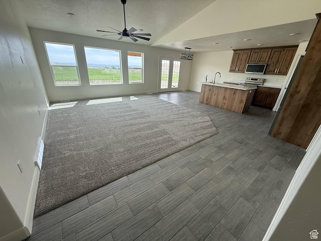 1030 N 200 E, Ferron, UT 84523 - kitchen featuring stainless steel appliances, open floor plan, a ceiling fan, a center island with sink, and light countertops