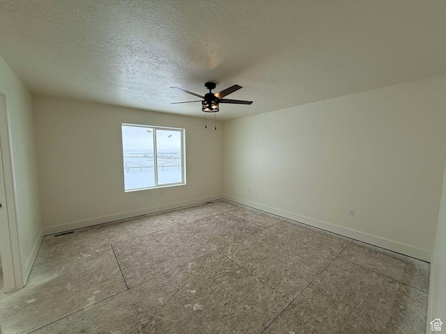 unfurnished room featuring baseboards, ceiling fan, and a textured ceiling