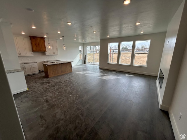 412 W 3085 S, Nibley, UT 84321 - unfurnished living room featuring recessed lighting, a wealth of natural light, dark wood-style flooring, and baseboards