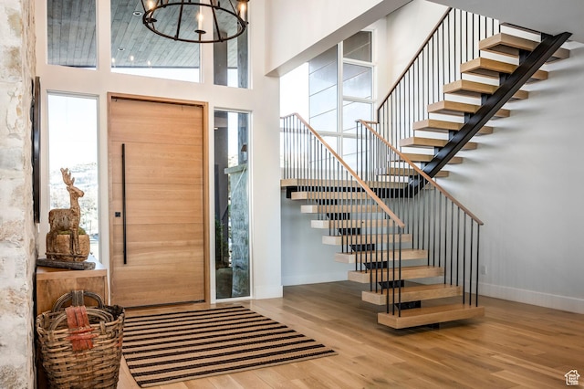 9491 N Promontory Summit Dr, Park City, UT 84098 - foyer entrance featuring baseboards, a towering ceiling, stairway, wood finished floors, and a chandelier