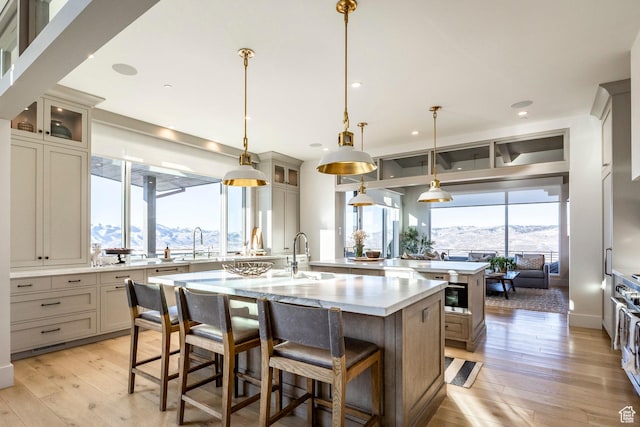 9491 N Promontory Summit Dr, Park City, UT 84098 - kitchen with an island with sink, glass insert cabinets, decorative light fixtures, light countertops, and a mountain view