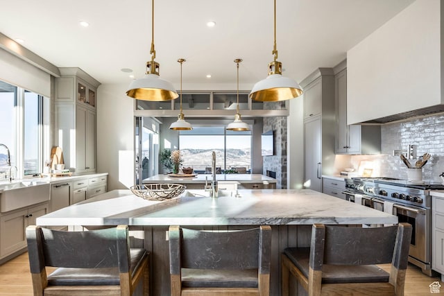 9491 N Promontory Summit Dr, Park City, UT 84098 - kitchen with range with two ovens, decorative light fixtures, a large island with sink, and a kitchen breakfast bar