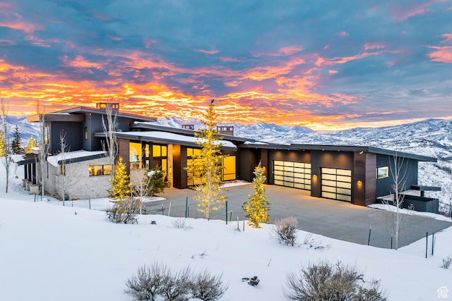 contemporary house with a mountain view, driveway, and an attached garage