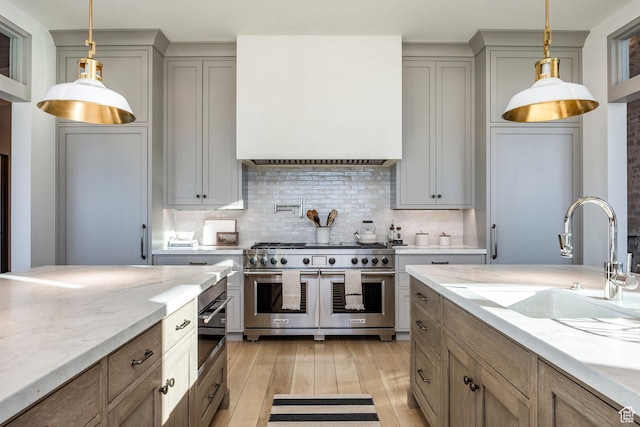 9491 N Promontory Summit Dr, Park City, UT 84098 - kitchen featuring hanging light fixtures, a sink, light wood-style flooring, and double oven range