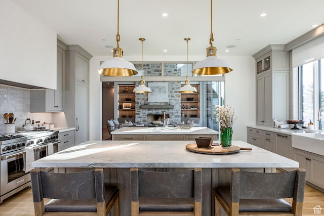 9491 N Promontory Summit Dr, Park City, UT 84098 - kitchen featuring high end stove, gray cabinets, open floor plan, and decorative light fixtures