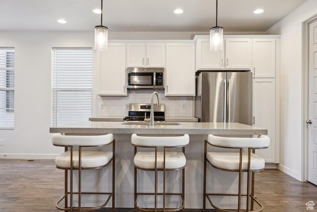 2344 N White Cliff Dr, Lehi, UT 84043 - kitchen featuring dark wood finished floors, backsplash, appliances with stainless steel finishes, a kitchen island with sink, and a sink