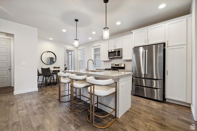 2344 N White Cliff Dr, Lehi, UT 84043 - kitchen with appliances with stainless steel finishes, an island with sink, dark wood finished floors, and decorative backsplash