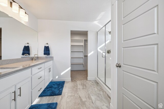 2344 N White Cliff Dr, Lehi, UT 84043 - bathroom with double vanity, a sink, a shower stall, and a spacious closet