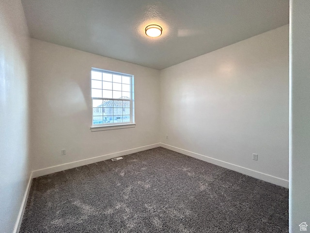 empty room featuring dark colored carpet