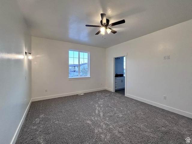 unfurnished room featuring ceiling fan and dark carpet