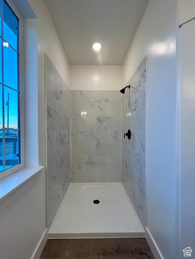 bathroom featuring wood-type flooring and tiled shower