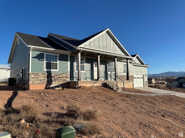 craftsman house with a porch, a garage, and a mountain view