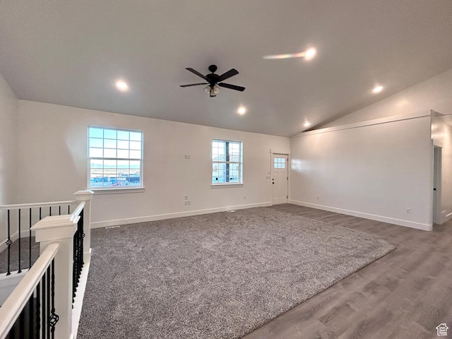 spare room with dark hardwood / wood-style floors, vaulted ceiling, and ceiling fan