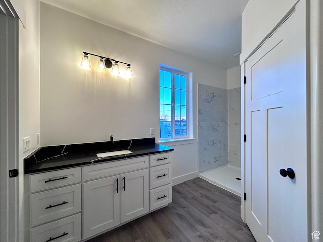 bathroom with vanity, hardwood / wood-style flooring, and a shower