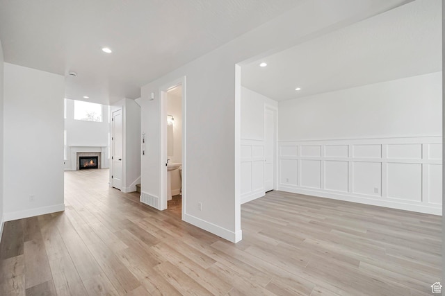 2946 N 1080 W, Lehi, UT 84043 - unfurnished room with recessed lighting, a warm lit fireplace, and light wood finished floors