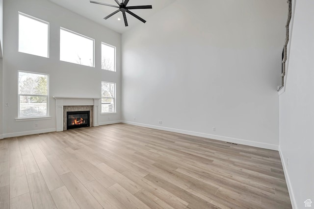 2946 N 1080 W, Lehi, UT 84043 - unfurnished living room featuring baseboards, a ceiling fan, light wood finished floors, and a towering ceiling