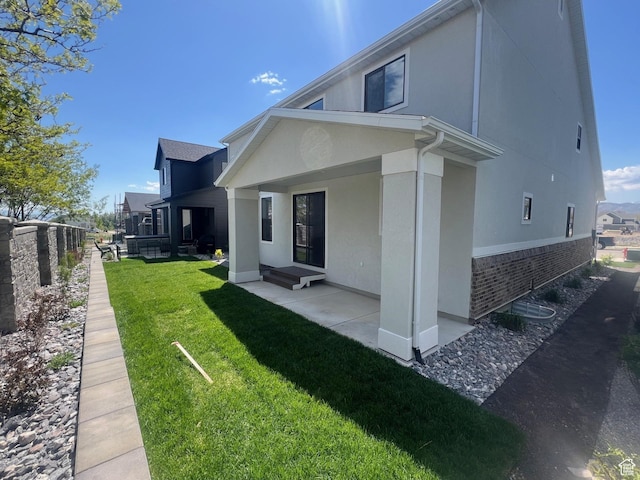 2946 N 1080 W, Lehi, UT 84043 - back of house with a patio, stucco siding, a yard, and brick siding