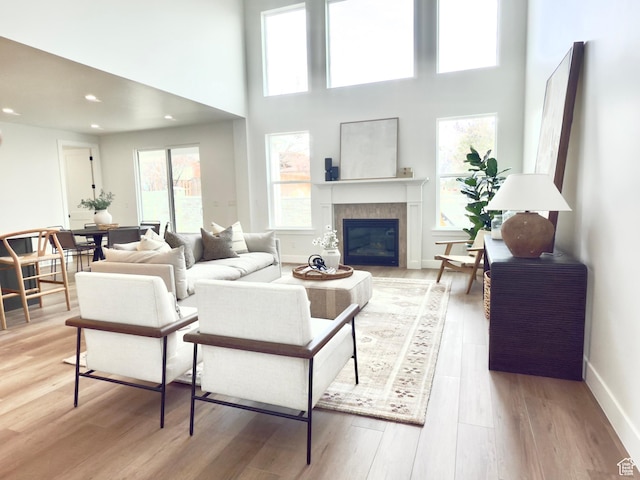 2946 N 1080 W, Lehi, UT 84043 - living room featuring a towering ceiling, light wood-style floors, baseboards, recessed lighting, and a tiled fireplace