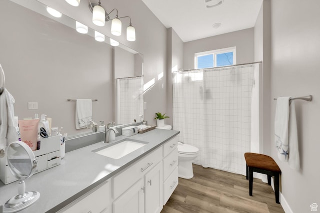 bathroom featuring vanity, toilet, curtained shower, and hardwood / wood-style flooring