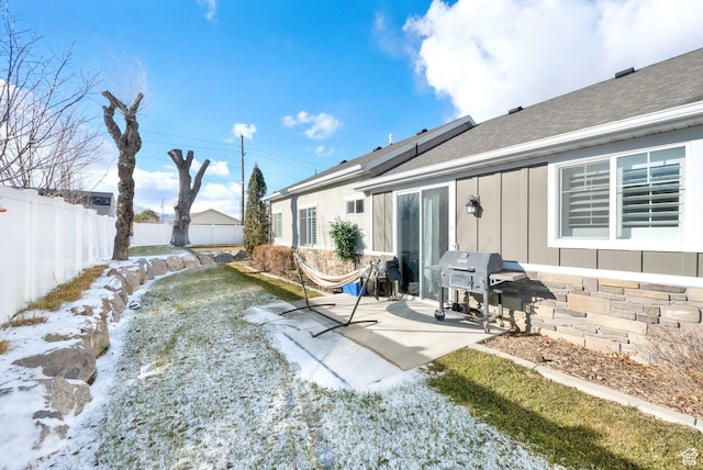 snow covered house featuring a patio area