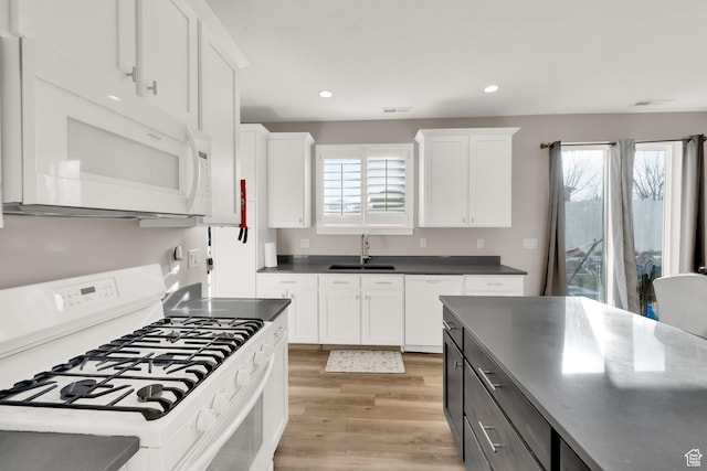 kitchen featuring white appliances, white cabinetry, sink, gray cabinets, and light wood-type flooring