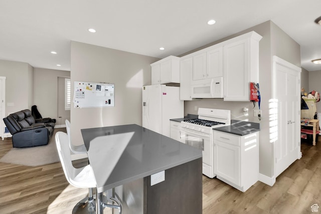 kitchen featuring white appliances, white cabinetry, and light hardwood / wood-style flooring